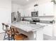 Modern kitchen featuring white cabinets, granite countertops, stainless steel appliances, and a functional island at 34355 Sorrel Mint Dr, Wesley Chapel, FL 33543