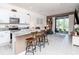 Open-concept kitchen with white cabinetry, granite countertops, island seating, and stainless steel appliances at 34355 Sorrel Mint Dr, Wesley Chapel, FL 33543