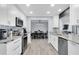 Modern kitchen features white cabinets, stainless steel appliances and an open view of the dining area at 3808 97Th N Ave, Pinellas Park, FL 33782
