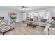 Bright living room featuring neutral paint, wood-look floors, ceiling fan, and large window with blinds at 3808 97Th N Ave, Pinellas Park, FL 33782
