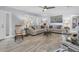 Spacious living room featuring neutral paint, wood-look floors, ceiling fan, and shuttered window coverings at 3808 97Th N Ave, Pinellas Park, FL 33782