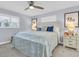 Comfortable main bedroom with ceiling fan, soft lighting, and beach-themed decor at 3808 97Th N Ave, Pinellas Park, FL 33782