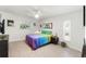 Bright bedroom featuring a colorful bed, ceiling fan, and natural light from a window at 408 Pineapple St, Tarpon Springs, FL 34689