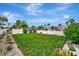 Neat backyard surrounded by white walls and a variety of tropical trees, shrubs, and plants at 4151 Belle Vista Dr, St Pete Beach, FL 33706