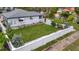 Well-maintained backyard with a neat lawn, white fence, and manicured landscaping at 4151 Belle Vista Dr, St Pete Beach, FL 33706