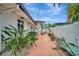 Private side yard with a concrete patio, white fence, and lush tropical landscaping at 4151 Belle Vista Dr, St Pete Beach, FL 33706