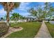 Inviting front yard with lush green lawn, mature trees, and charming walkway at 4151 Belle Vista Dr, St Pete Beach, FL 33706