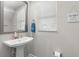 Half bathroom with a modern sink, mirror, and humorous wall decor at 4600 Lagona Ln, Wesley Chapel, FL 33543