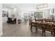 Open-concept living area with wood floors, white walls, and lots of natural light and sight into kitchen at 4600 Lagona Ln, Wesley Chapel, FL 33543