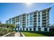 Beautiful condominium building with multiple balconies, surrounded by green lawns and a wooden walkway at 4801 Osprey S Dr # 508, St Petersburg, FL 33711