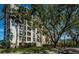 View of the building exterior showcasing multiple balconies, lush landscaping, and mature trees at 4801 Osprey S Dr # 508, St Petersburg, FL 33711