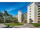Building exterior featuring lush landscaping, roundabout entry, and tile roofing at 4801 Osprey S Dr # 508, St Petersburg, FL 33711