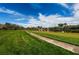 Expansive green space with a walking path and a serene lake reflecting the blue sky and scattered clouds at 4801 Osprey S Dr # 508, St Petersburg, FL 33711
