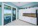 Kitchen with granite countertops, white cabinetry and views of the water and lanai at 4801 Osprey S Dr # 508, St Petersburg, FL 33711