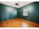 Empty bedroom with refinished hardwood floors, dark green walls, and a ceiling fan with overhead lighting at 5010 45Th N Ave, St Petersburg, FL 33709