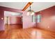 Bright dining room with hardwood floors, mauve walls, statement lighting, and access to other rooms at 5010 45Th N Ave, St Petersburg, FL 33709