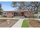 Charming brick home with metal roof, manicured landscaping, and inviting front porch at 5010 45Th N Ave, St Petersburg, FL 33709