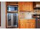 Kitchen featuring stainless steel appliances, a built-in wine fridge, wood cabinets, and granite countertops at 5010 45Th N Ave, St Petersburg, FL 33709