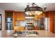 Well-lit kitchen with stainless steel appliances, wood cabinets, an island sink, and designer lighting at 5010 45Th N Ave, St Petersburg, FL 33709