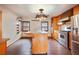 Open kitchen featuring an island with a sink, stainless steel appliances, and hardwood floors at 5010 45Th N Ave, St Petersburg, FL 33709