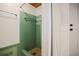 This bathroom features a green tiled shower with vintage fixtures and an adjacent doorway at 5010 45Th N Ave, St Petersburg, FL 33709
