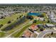 Aerial view of a charming home nestled in a tranquil neighborhood near a serene pond at 607 Fox Hills Dr, Sun City Center, FL 33573