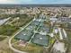 Aerial view of the community, with tennis courts and a lake with verdant landscaping at 607 Fox Hills Dr, Sun City Center, FL 33573