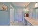 Hallway bathroom with long vanity, marble counters, pendant lighting, and a mirror at 607 Fox Hills Dr, Sun City Center, FL 33573