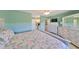 Bedroom featuring seafoam green walls, a queen size bed, and an open door to the Primary bathroom at 607 Fox Hills Dr, Sun City Center, FL 33573