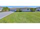 Well-maintained single story home with a green lawn and a two car garage with driveway at 607 Fox Hills Dr, Sun City Center, FL 33573