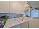 Bright laundry room with washer, dryer, cabinets, and window at 607 Fox Hills Dr, Sun City Center, FL 33573