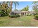 A sprawling backyard with a well-maintained lawn, lush trees, and screened-in porch offering serene outdoor living at 6109 Kingbird Manor Dr, Lithia, FL 33547