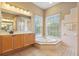 Bright bathroom featuring a soaking tub, vanity, and glass enclosed shower at 6109 Kingbird Manor Dr, Lithia, FL 33547