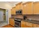 Kitchen featuring light wood cabinets, tile backsplash, stainless steel oven, and granite countertops at 6109 Kingbird Manor Dr, Lithia, FL 33547