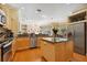 Bright kitchen features wood floors, stainless steel appliances, granite countertops, and central island at 6109 Kingbird Manor Dr, Lithia, FL 33547