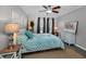 Bright bedroom features a ceiling fan, a bed with a turquoise quilt, and a natural fiber rug at 704 Lyndhurst St # 604, Dunedin, FL 34698