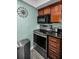 Modern kitchen featuring stainless steel stove, microwave, and dark cabinetry at 704 Lyndhurst St # 604, Dunedin, FL 34698