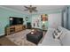 Bright living room with a ceiling fan, a grey couch, and doors leading outside at 704 Lyndhurst St # 604, Dunedin, FL 34698