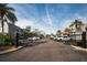 View of the parking lot featuring gated entrance, mature trees and well-maintained landscaping at 704 Lyndhurst St # 604, Dunedin, FL 34698