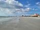 Beautiful beach scene with soft sand, clear water, and a historic pink hotel in the distance at 7300 Sun Island S Dr # 202, South Pasadena, FL 33707