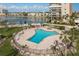 Beautiful community pool and hot tub overlook the bay, with lounge chairs and manicured landscaping at 7300 Sun Island S Dr # 202, South Pasadena, FL 33707