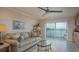 Cozy living room features a ceiling fan, water view balcony access, and comfortable seating at 7300 Sun Island S Dr # 202, South Pasadena, FL 33707