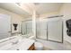 Clean bathroom with a large mirror, vanity, toilet, and bathtub with sliding glass doors at 7924 Carriage Pointe Dr, Gibsonton, FL 33534
