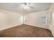 Spacious carpeted bedroom with a ceiling fan, two windows letting in natural light, and a door to the exterior at 7924 Carriage Pointe Dr, Gibsonton, FL 33534