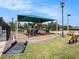 A modern playground with slides and climbing structures is shaded by a green canopy and surrounded by benches at 7924 Carriage Pointe Dr, Gibsonton, FL 33534