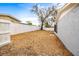 View of the fenced backyard with a large shade tree at 9216 Mark Twain Ln, Port Richey, FL 34668