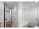 Bathroom with white tiled shower, accent wall, and access to another room at 9216 Mark Twain Ln, Port Richey, FL 34668
