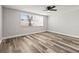 Bright bedroom with new floors, fresh paint, a ceiling fan, and large windows to let in plenty of light at 9216 Mark Twain Ln, Port Richey, FL 34668