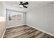 Comfortable bedroom with new flooring, a ceiling fan and a window providing ample natural light at 9216 Mark Twain Ln, Port Richey, FL 34668