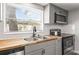Bright kitchen with stainless appliances, gray cabinets, and butcher block countertops at 9216 Mark Twain Ln, Port Richey, FL 34668